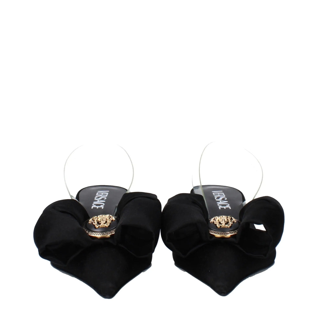 Sandales plates versace noires en satin avec nœud, brides transparentes et emblème medusa doré