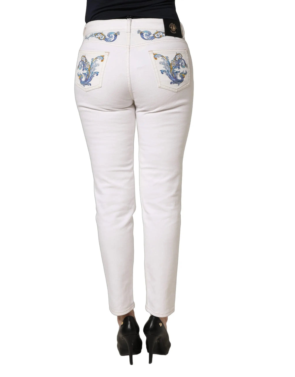 Vue arrière d un jean skinny en denim blanc versace jeans couture avec broderie florale bleue et dorée aux poches et ceinture