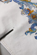 Jeans skinny en denim blanc versace jeans couture avec motif floral bleu et or baroque orné sur tissu blanc