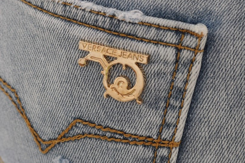 Jeans slim stretch bleu délavé avec déchirures et coupe ajustée de Versace Jeans, style décontracté et tendance.
