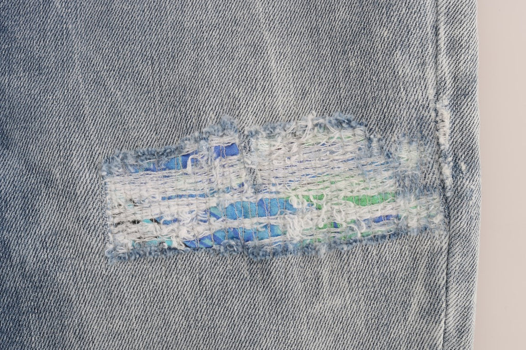 Jeans slim stretch déchirés bleu wash de Versace Jeans, coupe ajustée et moderne, visible avec détails déchirés et finition soignée.