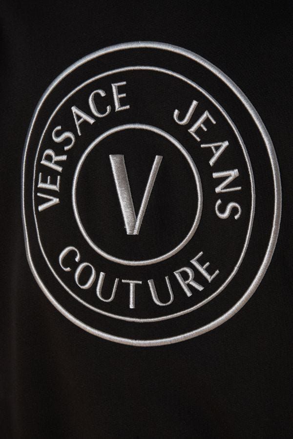 Sweat à capuche noir en coton Versace Jeans avec logo et détails de marque, porté sur un mannequin.