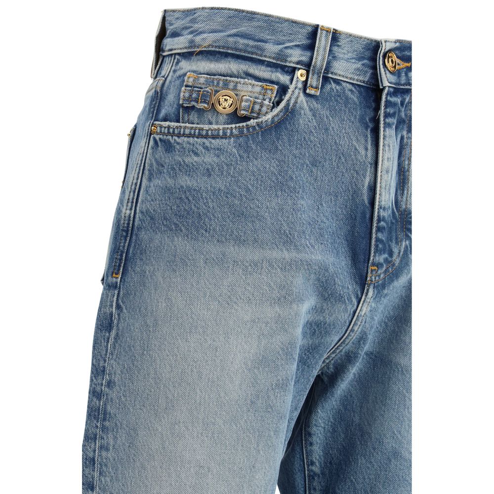 Jeans en denim coton bleu de la marque Versace, coupe classique, visible avec détails de couture et logo distinctif.