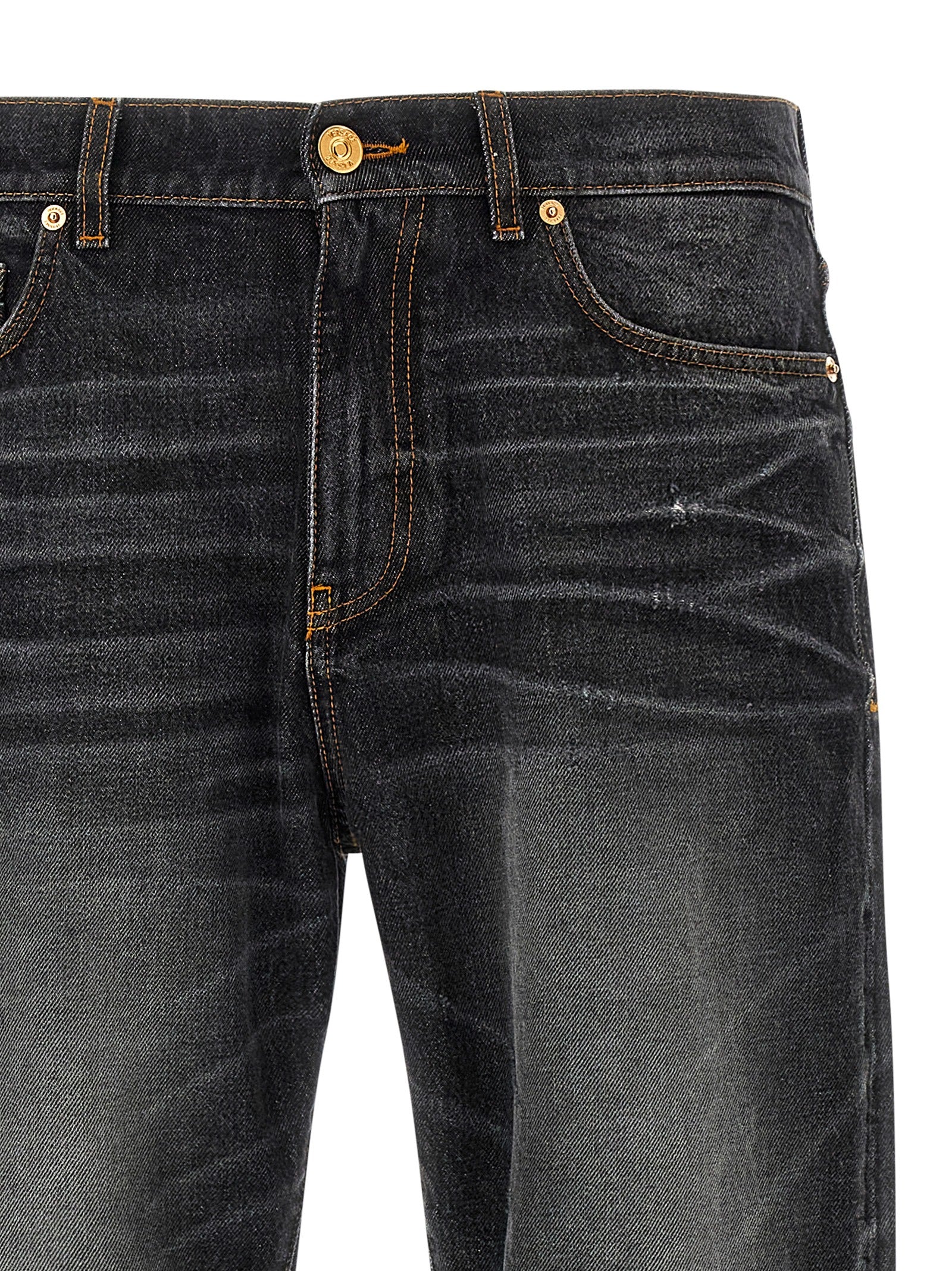Jeans droits en coton noir de la marque Versace, détail élégant et coupe classique, visibles sur l'image.