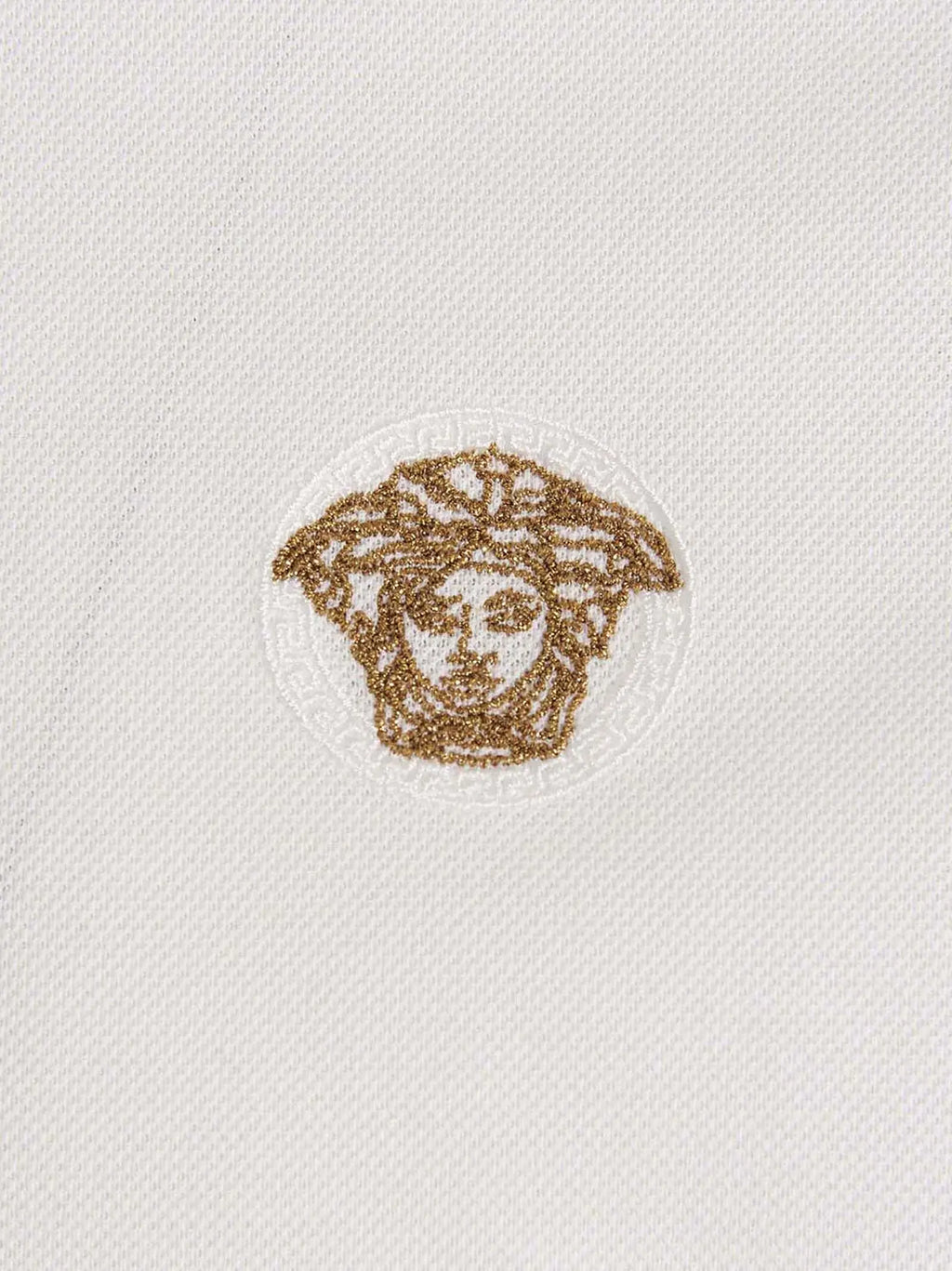 Polo blanc versace en coton avec logo medusa brodé en or sur la poitrine