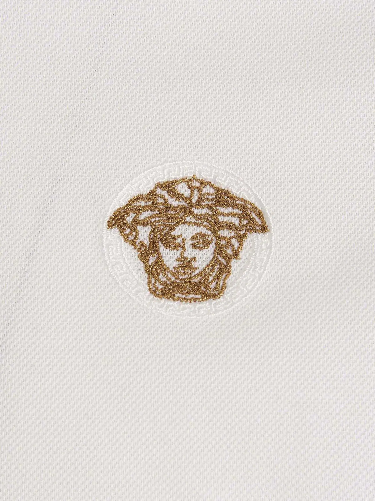 Polo blanc versace en coton avec logo medusa brodé en or sur la poitrine
