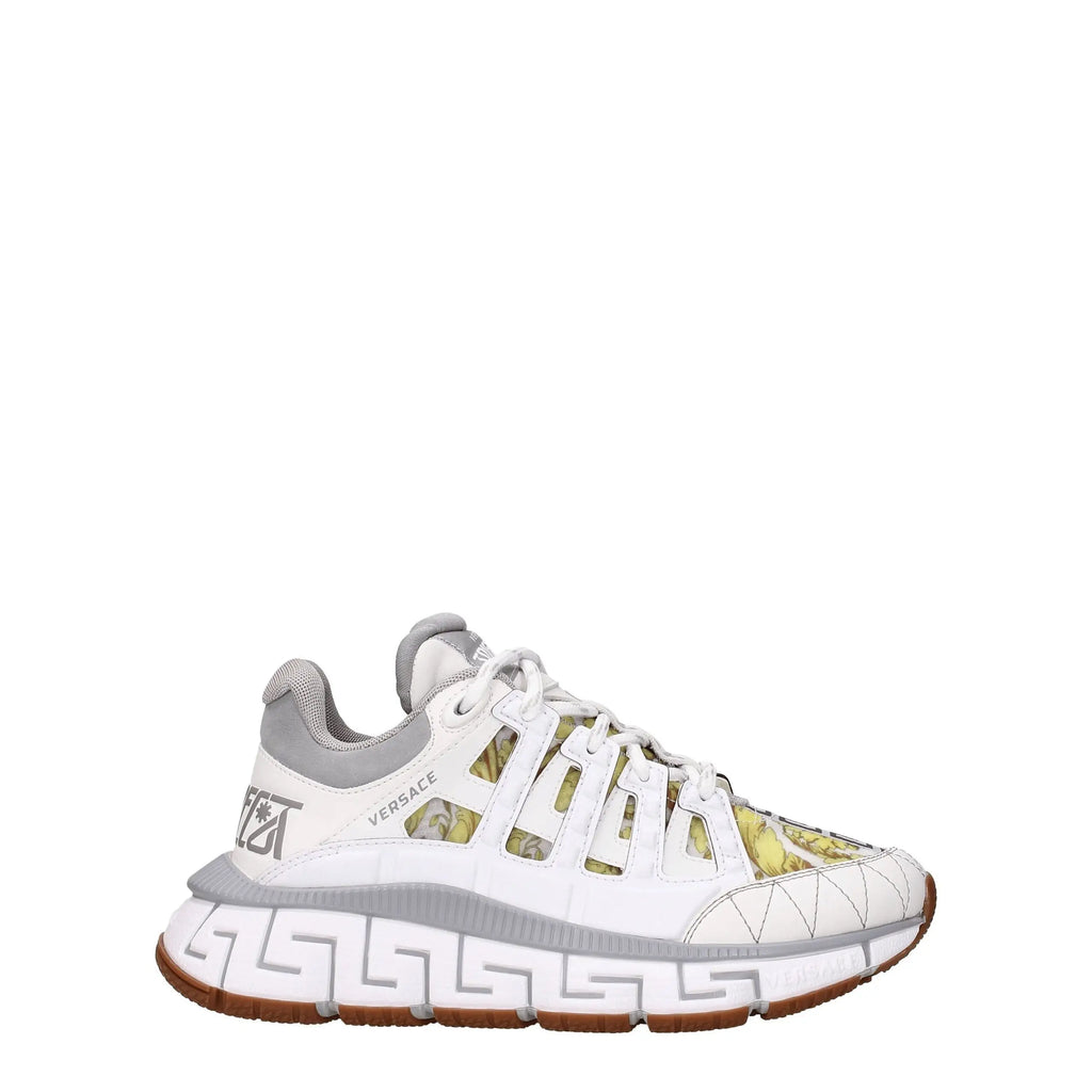 Versace white leather athletic sneakers with gray accents, Greek key pattern sole, and translucent panels showing greenish-yellow print